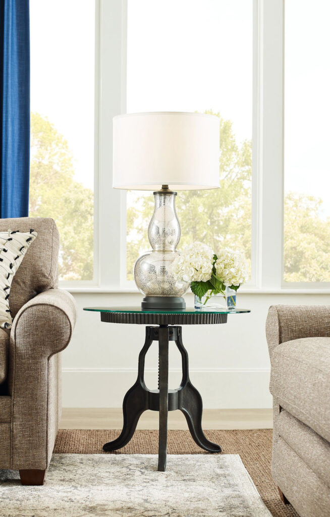 end table with a clear lamp on it